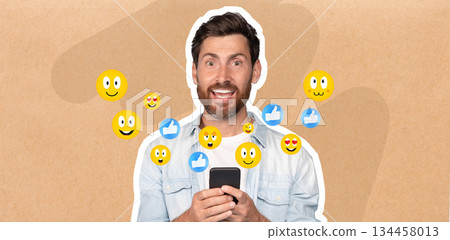 A man is happily interacting with his smartphone, smiling as he texts friends. Colorful emojis surround him, expressing joy and engagement in social media conversations. 134458013