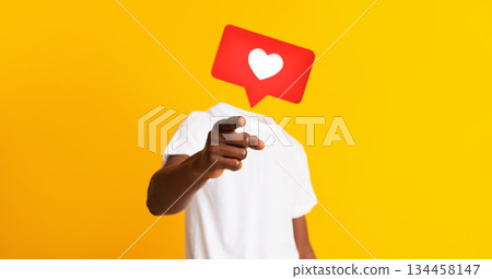 A person in a white shirt gestures with a pointing finger against a bright yellow background, featuring a heart icon instead of their head, depicting social media engagement and connection. A person in a white shirt gestures with a pointing finger against a bright yellow background, featuring a heart icon instead of their head, depicting social media engagement and connection. 134458147