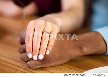 She Said Yes. Closeup Shot Of Female Hand With Engagement Ring Holding Black Boyfriend's Hand During Romantic Date Dinner In Restaurant, Couple Celebrating Emgagement, Cropped Image 134458257