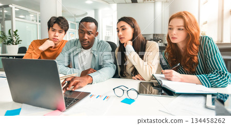 Studying Together. Focused diverse multiracial students sitting at desk in auditorium using laptop, watching tutorial or educational video, doing research and making group project for college 134458262