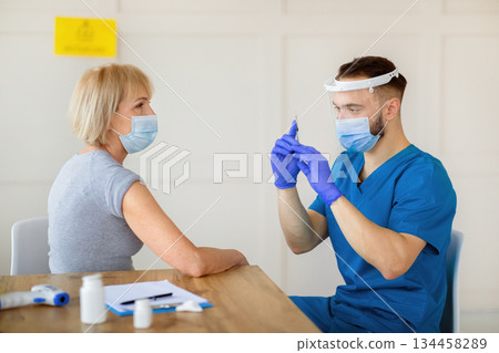 Senior Caucasian woman having covid-19 vaccine injection at hospital. Mature lady receiving coronavirus immunization at clinic. Medical care and health services concept 134458289