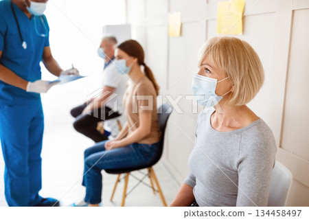 Senior woman waiting for covid-19 vaccine injection, doctor checking patients' health before immunization at clinic. Coronavirus vaccination, protection against viral diseases campaign 134458497