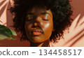 A peaceful young black woman with eyes closed basks in the warm indoor sunlight, showing a serene expression. A peaceful young black woman with eyes closed basks in the warm indoor sunlight, showing a serene expression. 134458517