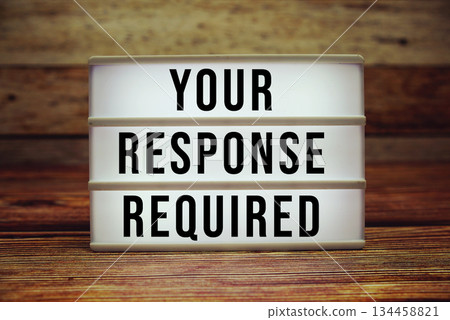 Lightbox with text "Your Response Required" on wooden background Lightbox with text "Your Response Required" on wooden background 134458821