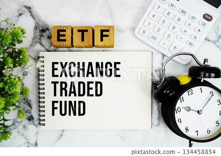 ETF Exchange Traded Fund text with calculator and alarm clock on marble background ETF Exchange Traded Fund text with calculator and alarm clock on marble background 134458854