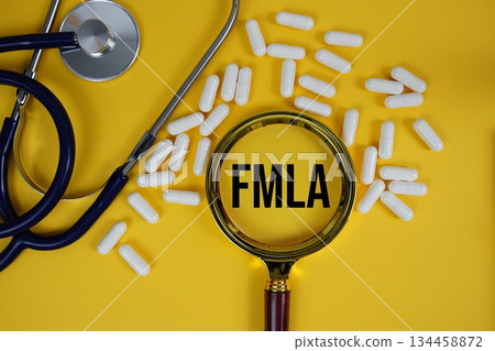 FMLA abbreviation of Family Medical Leave Act text with Stethoscope and magnifying glass flat lay on yellow background FMLA abbreviation of Family Medical Leave Act text with Stethoscope and magnifying glass flat lay on yellow background 134458872