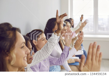 Diverse women have questions and raise their hands after a business presentation Diverse women have questions and raise their hands after a business presentation 134459134