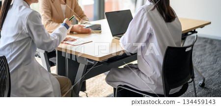 Doctor and business person consulting in a conference room Doctor and business person consulting in a conference room 134459143