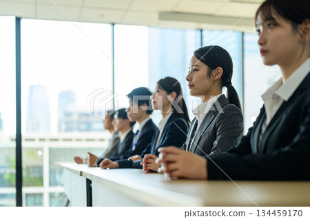 Men and women in suits listening seriously to a seminar 134459170