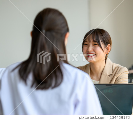 兩位面帶微笑的女士在諮詢室裡交談。 134459173