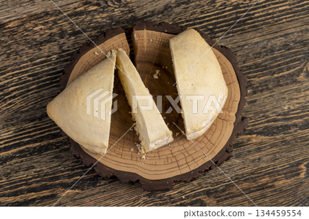sliced fresh shortbread bun with juicy curd filling on a wooden board on the table, soft pastries stuffed with cottage cheese sliced fresh shortbread bun with juicy curd filling on a wooden board on the table, soft pastries stuffed with cottage cheese 134459554