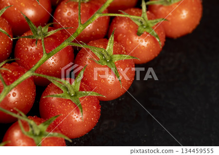 wet ripe red round tomatoes on a black slate board, sweet fresh round tomatoes covered with water droplets on a black board after harvesting wet ripe red round tomatoes on a black slate board, sweet fresh round tomatoes covered with water droplets on a black board after harvesting 134459555
