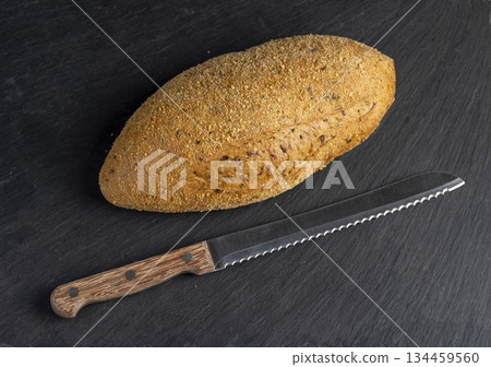 a fresh soft bread on black slate, a freshly baked soft loaf of rye bread lies on the table 134459560
