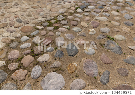 a road made of stones of different sizes in rural areas, a reconstructed ancient road made of multicolored cobblestones and pebbles a road made of stones of different sizes in rural areas, a reconstructed ancient road made of multicolored cobblestones and pebbles 134459571
