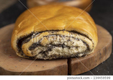 fresh wheat bun with lots of poppy , soft bun with poppy seeds on the table fresh wheat bun with lots of poppy , soft bun with poppy seeds on the table 134459599