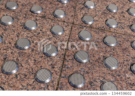 metal elevations on the pavement tiles to ensure safety during rain and frost, anti-slip inserts on the tiles to ensure pedestrian safety in bad weather, close up metal elevations on the pavement tiles to ensure safety during rain and frost, anti-slip inserts on the tiles to ensure pedestrian safety in bad weather, close up 134459602