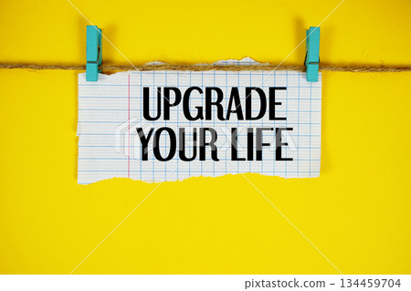 Upgrade Your Life text written on rip paper with wooden clip on yellow background 134459704