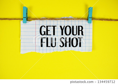 Get Your Flu Shot text written on rip paper with wooden clip on yellow background Get Your Flu Shot text written on rip paper with wooden clip on yellow background 134459712