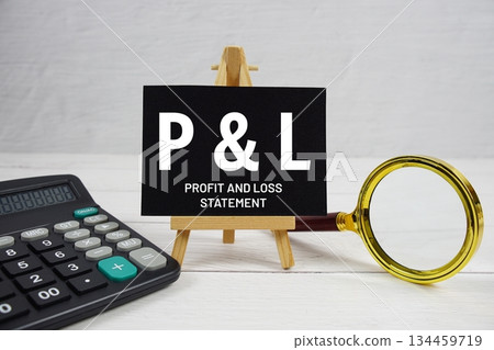 P and L abbreviation of Profit And Loss Statement text with magnifying glass and calculator on wooden background 134459719