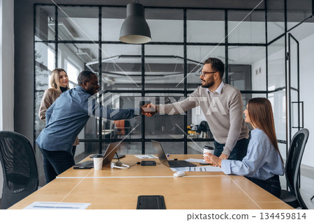 Shaking hands, greetings. Professional workers are in the modern office together 134459814