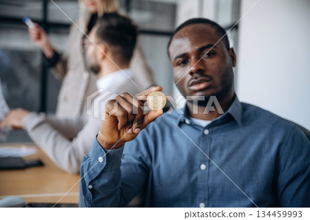 Crypto currency, coin in hand. Professional workers are in the modern office together Crypto currency, coin in hand. Professional workers are in the modern office together 134459993
