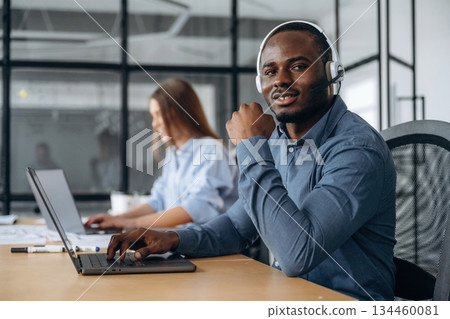 People are working in the call center in headphones and laptops People are working in the call center in headphones and laptops 134460081