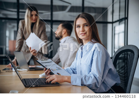 Documents in hands. Professional workers are in the modern office together 134460118