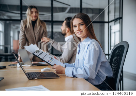 Documents in hands. Professional workers are in the modern office together Documents in hands. Professional workers are in the modern office together 134460119