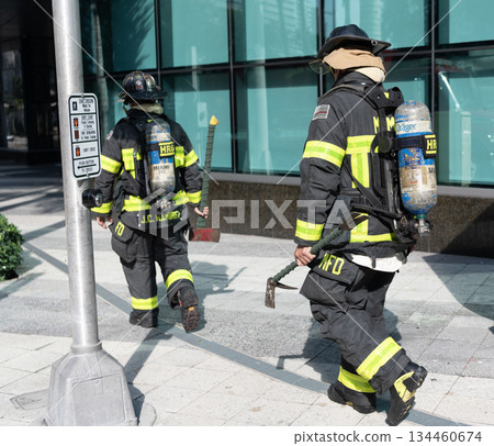 Miami, Florida, USA - December 01, 2024: 911 emergency. Firefighter in uniform. Team group of fireman. Firefighter teamwork in fire suit on rescue duty using water from hose. Fireman of Miami 134460674