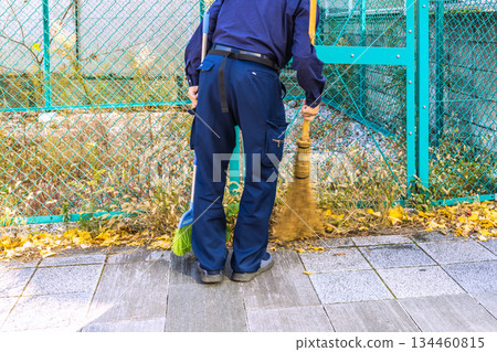 日本東京的城市景觀，年末…老化社會。一位老人正在清掃落葉，但他沒有使用簸箕（落葉，P，B）。 134460815