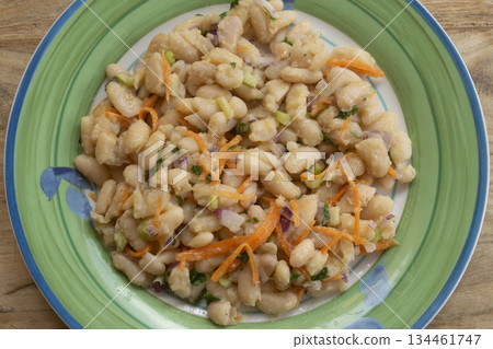 white bean salad with carrots and herbs on green plate close up white bean salad with carrots and herbs on green plate close up 134461747