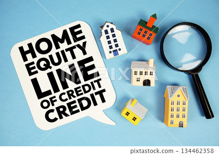 HELOC Home Equity Line Of Credit text with house models on blue background HELOC Home Equity Line Of Credit text with house models on blue background 134462358