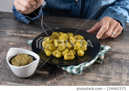 Woman eating gnocchi with pesto sauce Woman eating gnocchi with pesto sauce 134462575
