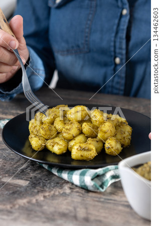Woman eating gnocchi with pesto sauce Woman eating gnocchi with pesto sauce 134462603