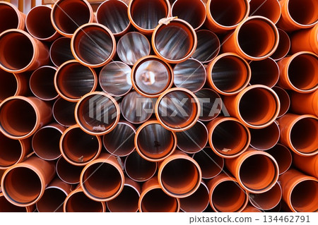 Stacked Orange PVC Pipes Close-Up 134462791