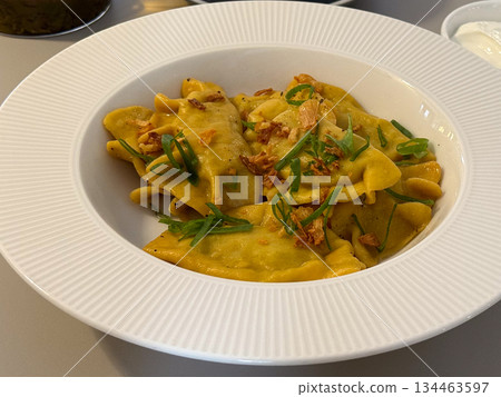 Close-up Ravioli lunch in cafe table setting. Comfort dining, restaurant cuisine, appetite, leisure, nutrition experience and relaxed meal atmosphere 134463597