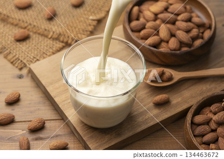 Almond milk and nuts poured into a glass Almond milk and nuts poured into a glass 134463672