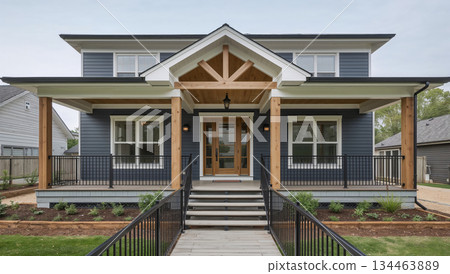 Modern suburban house with a welcoming covered porch and natural wood accents 134463889