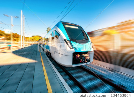 High-speed blue passenger train moving at railway station 134463964