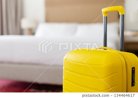 Yellow suitcase standing near bed in modern bedroom interior. Travel lifestyle concept 134464617