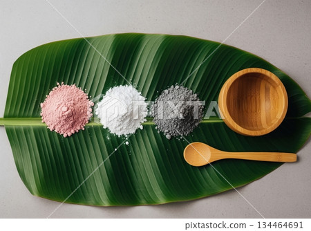 Organic skincare ingredients, cosmetic clay powders, wooden bowl, and spoon on banana leaf. Organic skincare ingredients, cosmetic clay powders, wooden bowl, and spoon on banana leaf. 134464691