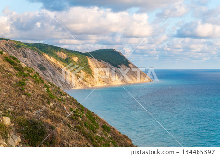 High mountain slopes to the Black Sea coast in Anapa, Russia. Coastline in sunset, beautiful sea scenery. Anapa coast landscape, high cliff High mountain slopes to the Black Sea coast in Anapa, Russia. Coastline in sunset, beautiful sea scenery. Anapa coast landscape, high cliff 134465397