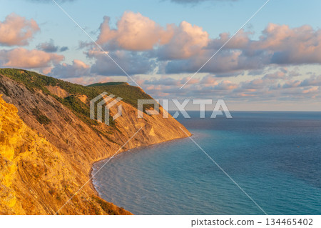 High mountain slopes to the Black Sea coast in Anapa, Russia. Coastline in sunset, beautiful sea scenery. Anapa coast landscape, high cliff High mountain slopes to the Black Sea coast in Anapa, Russia. Coastline in sunset, beautiful sea scenery. Anapa coast landscape, high cliff 134465402