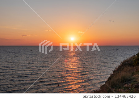 Beautiful red and orange sunrise over the sea. Beautiful red and orange sunrise over the sea. 134465426