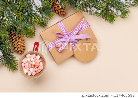 Gift box, cup with marshmallows, snowy fir branches 134465592