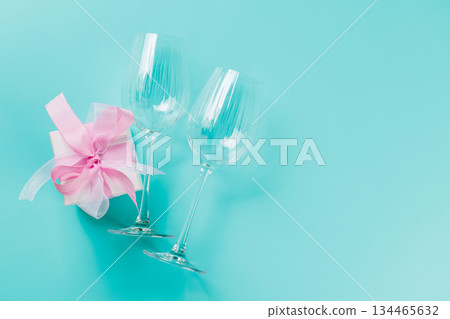 Gift box and wine glasses on blue background 134465632