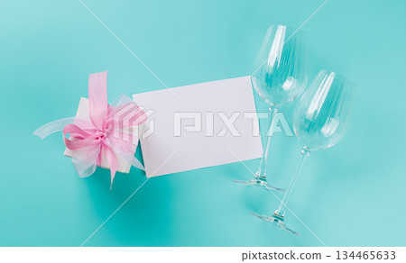 Gift box and wine glasses on blue background 134465633