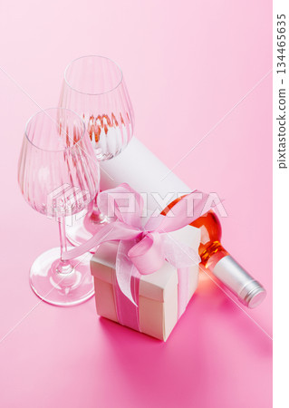 Gift box and wine glasses on pink background 134465635