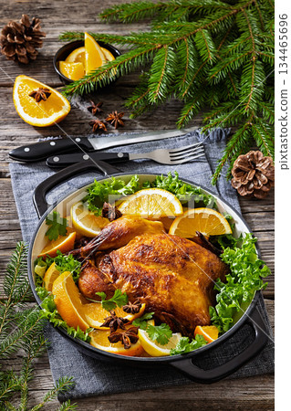 Whole roasted chicken in baking dish with citrus 134465696