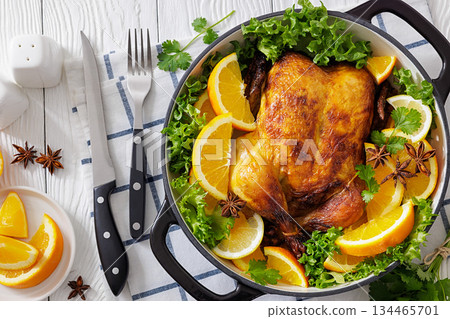 Whole roasted chicken in baking dish with citrus 134465701
